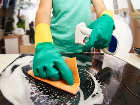 Local specialist cleaning a tile floor in a Swisscottage property